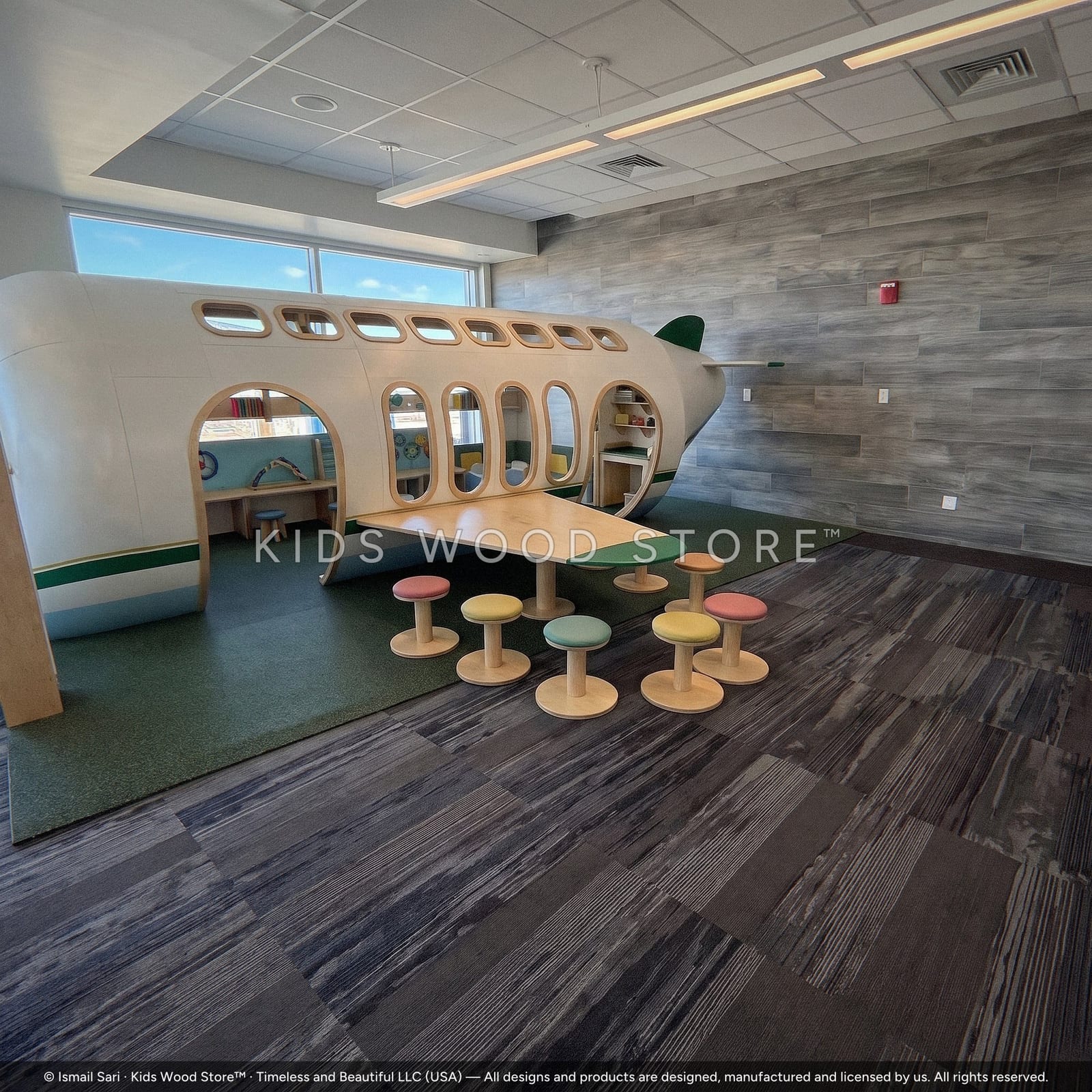 Airplane play structure with wing table and round stools in an airport play area